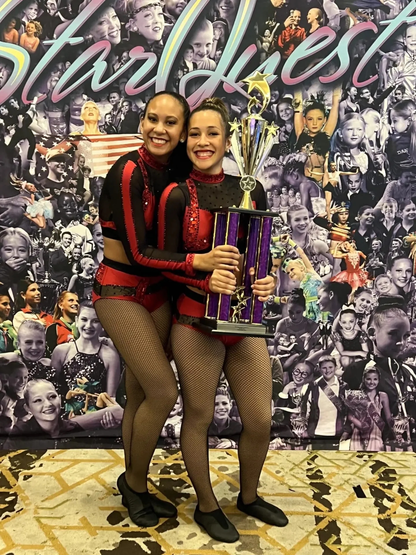 Two dancers holding a trophy with smiles.