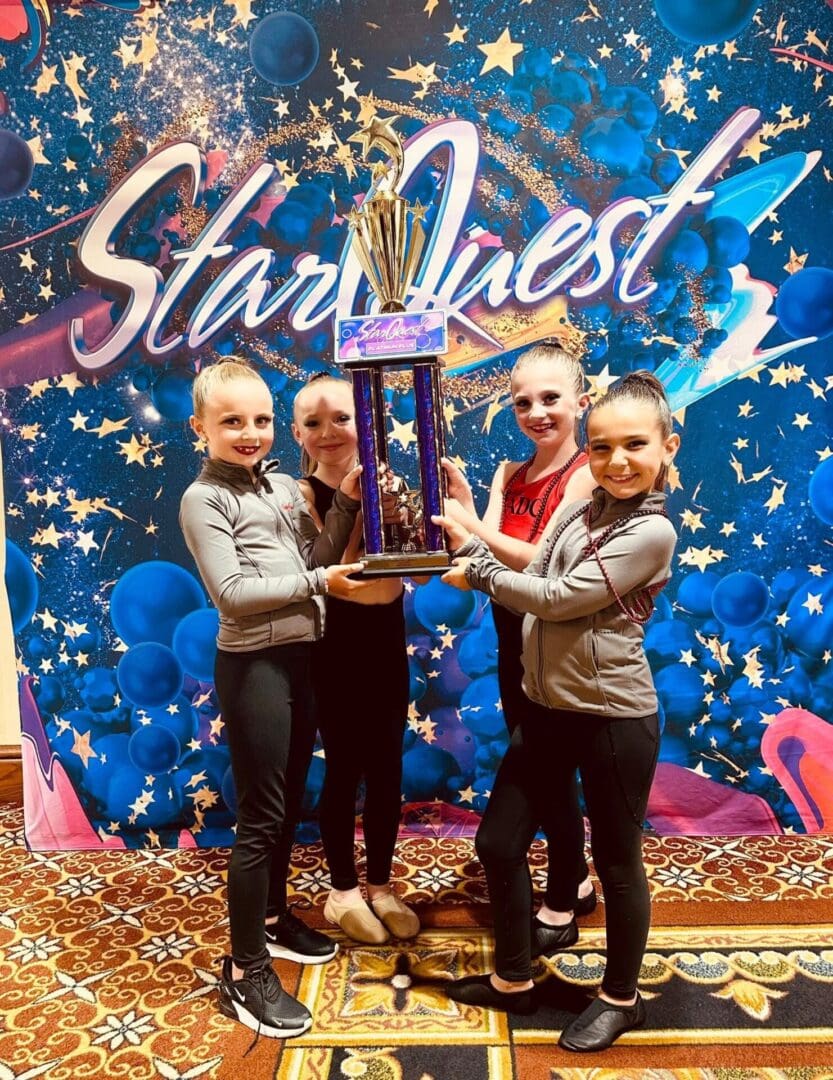 Three people holding a large trophy at a Starlines event.