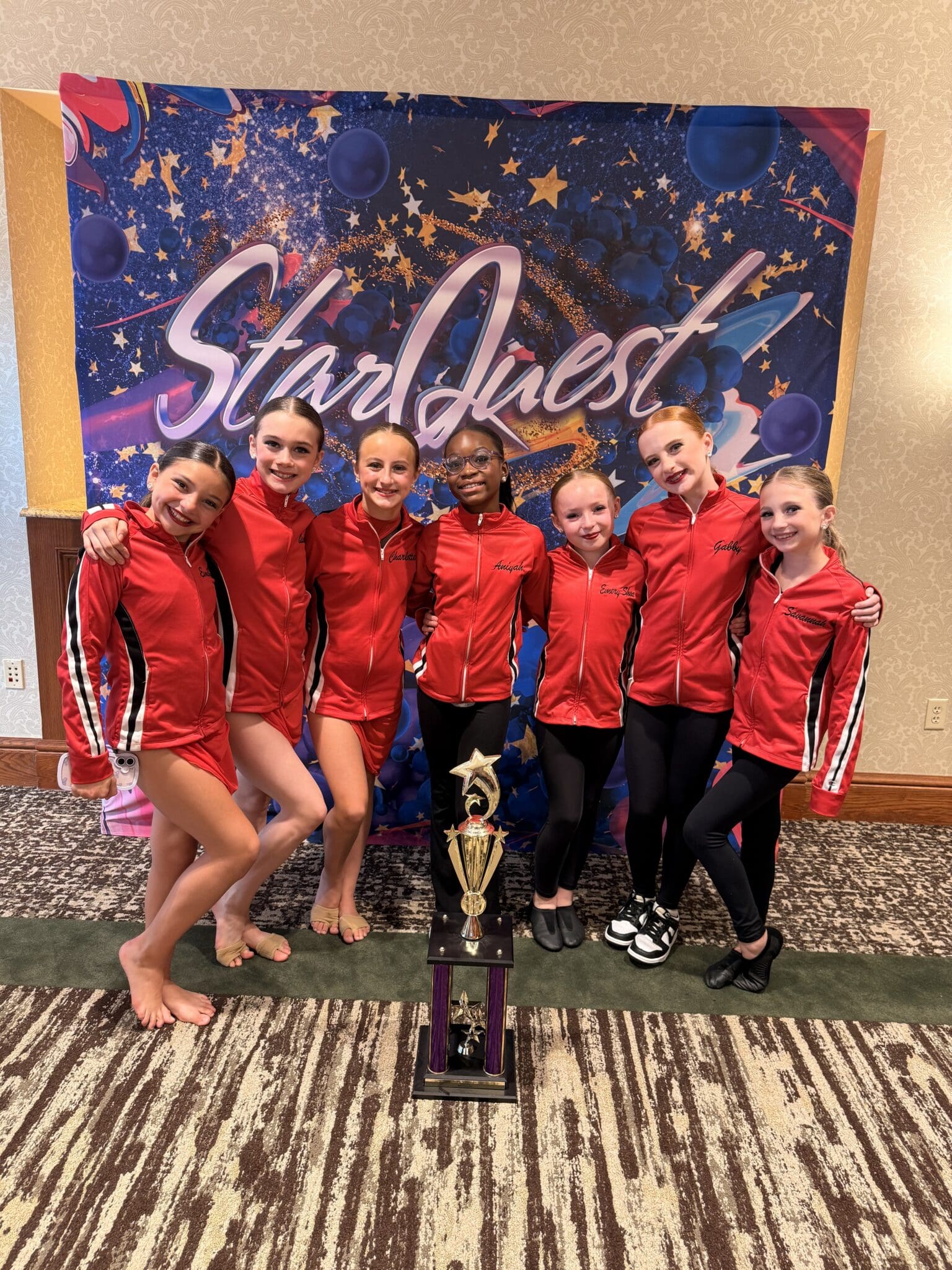 Dance team in red jackets with trophy