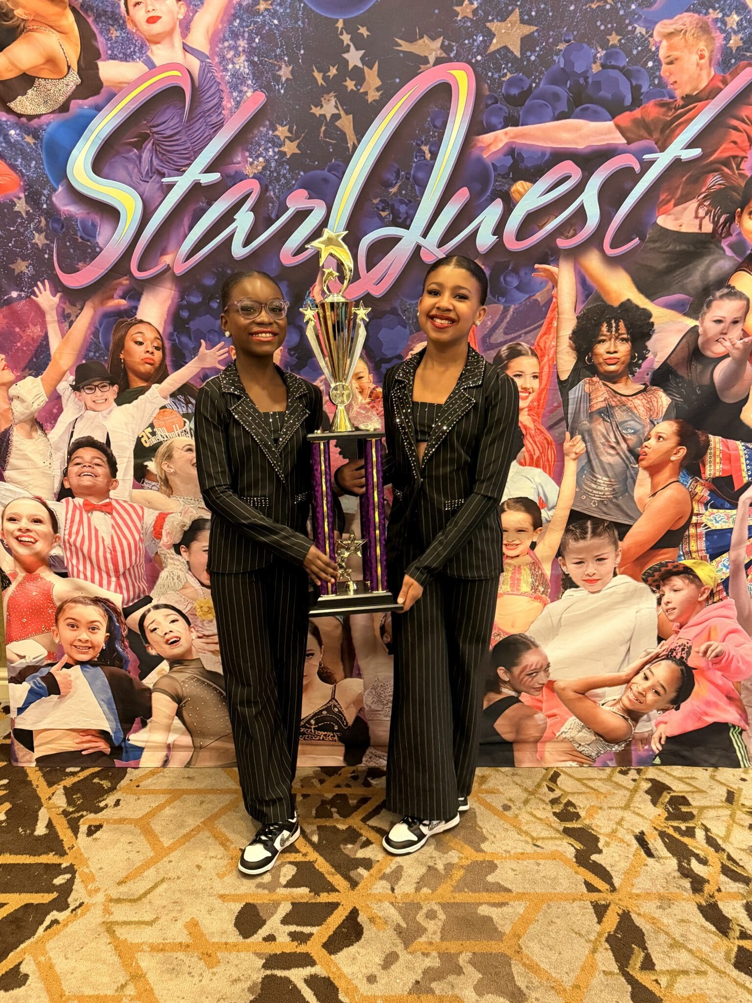 Two dancers holding large trophy at StarQuest