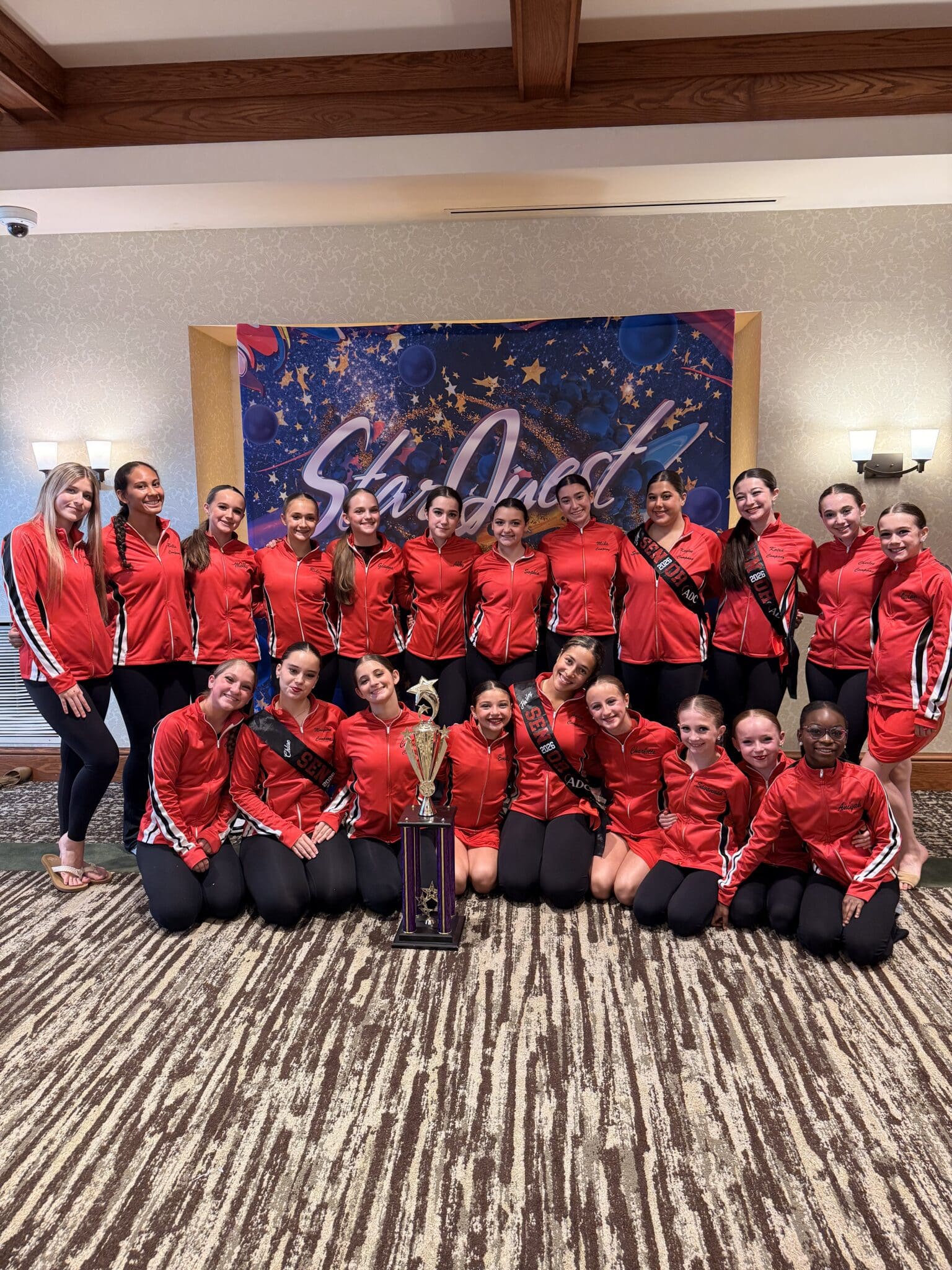 Dance team in red jackets with trophy