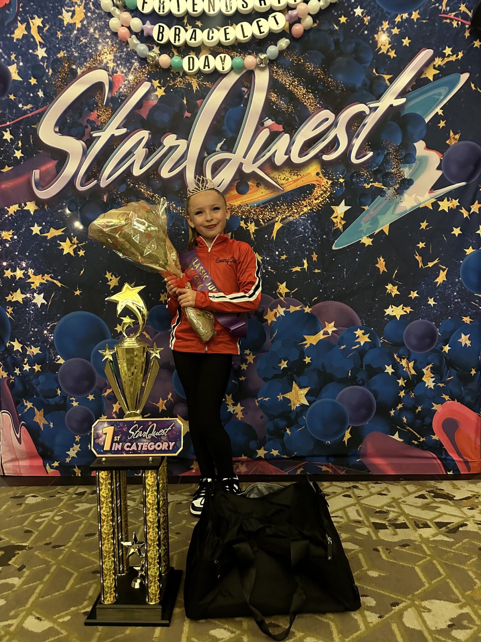 Young dancer with trophy and bouquet