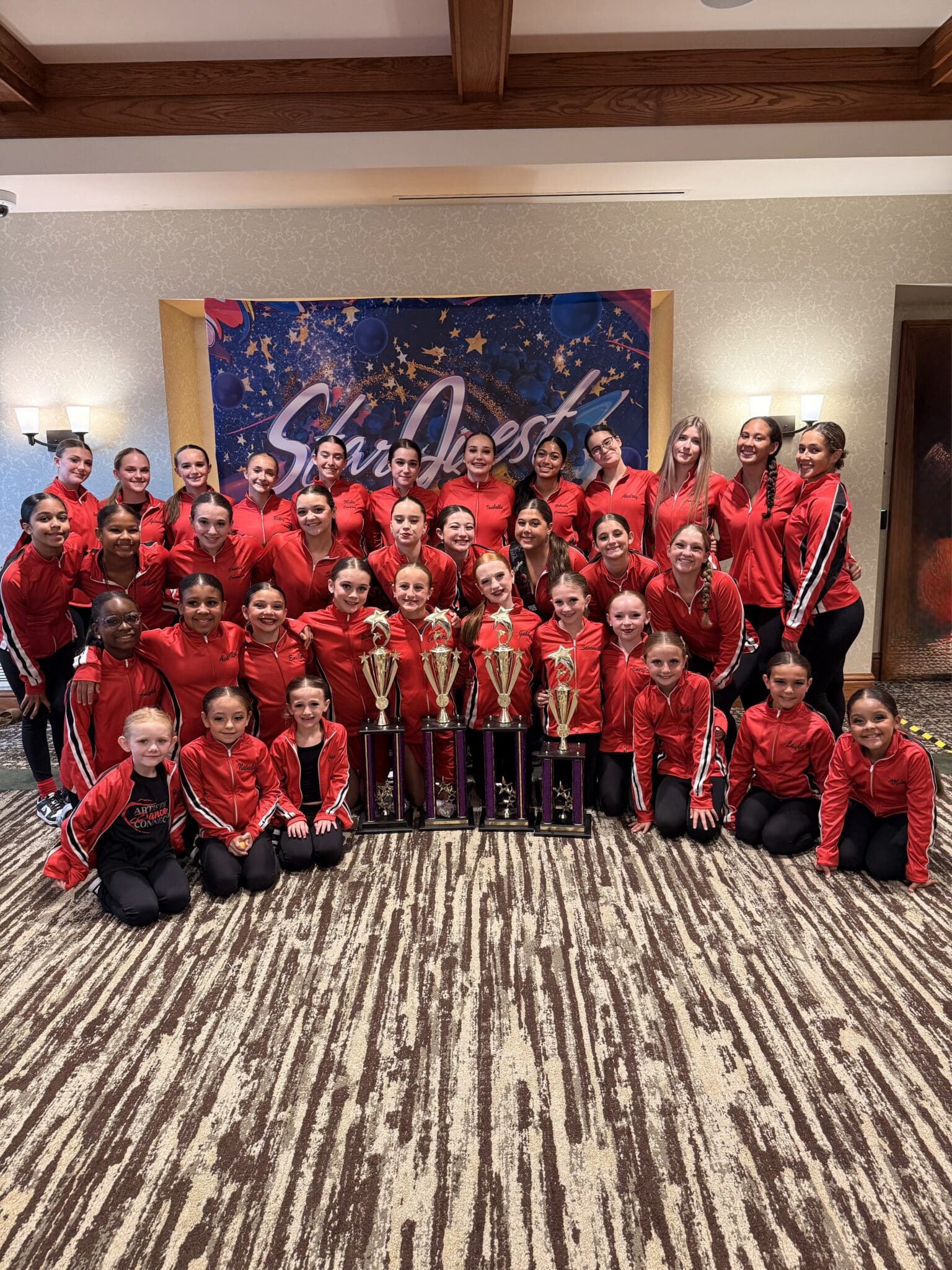 Youth dance team in red jackets with trophies